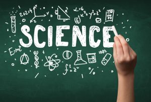 A teacher writing science, drawing chemistry elements on clean g