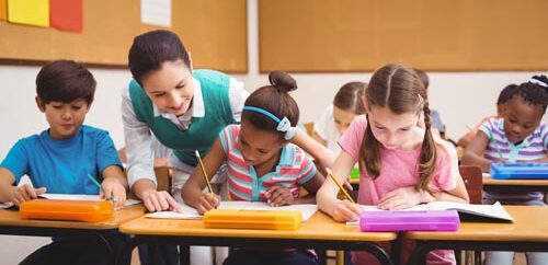 Teacher helping pupils during class at the elementary school